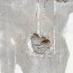 Water stains and peeling plaster damage on a concrete wall, revealing signs of a hidden plumbing leak inside the home.